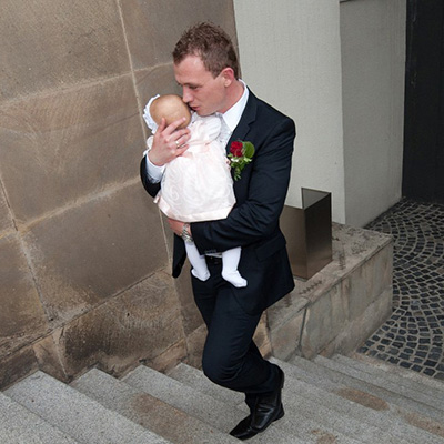 Leiser Moment einer Hochzeitsreportage: Braeutigam mit baby